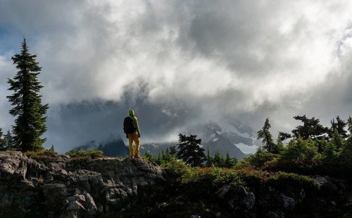 Hiker in front of cloudy Mt. Shuksan with snow and glacier