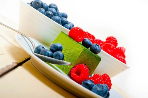 Green tea matcha mousse cake with raspberries and blueberries on top