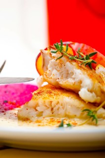 Sea bream orata fillet butter pan fried with fresh peach prune and dragonfruit slices thyme on top