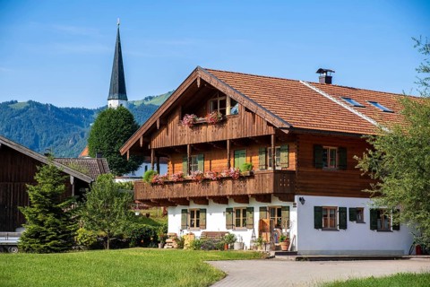Dilchinger Hof in front of the tower of the Filial Church of the Assumption of the Virgin Mary