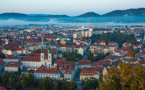 Cityscape of Graz with Mur river and Mariahilfer church