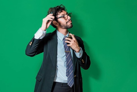Elegant businessman perfuming himself and combing his hair