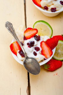 Fruit and yogurt salad healthy breakfast over white wood table