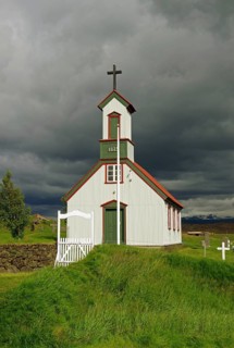 Wooden church and peat houses against dark clouds