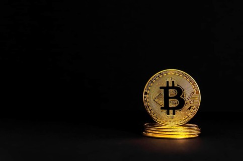 Bitcoin BTC crypto currency gold coins on black background