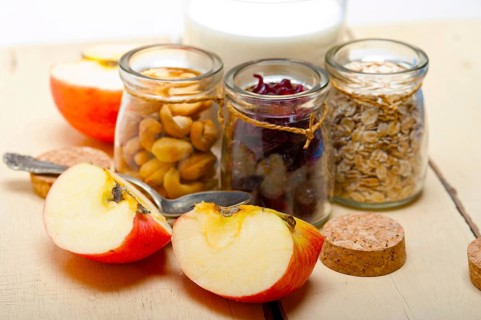 Healthy breakfast ingredients milk oat cashew nuts dried cramberry craisinns