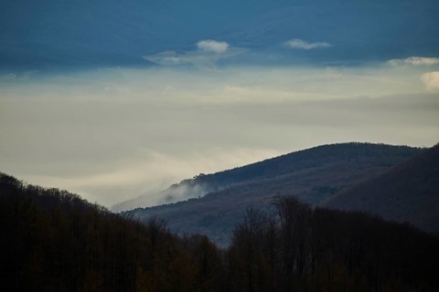 Fog lying in a valley at sunset