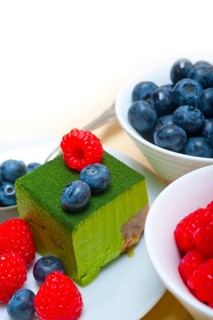 Green tea matcha mousse cake with raspberries and blueberries on top