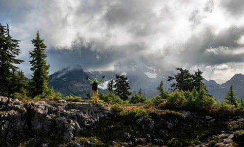 Hiker stretches his arms in the air