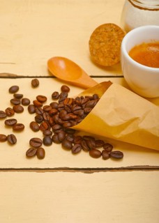 Espresso coffee and beans on a paper cone cornucopia over white background
