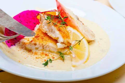 Sea bream orata fillet butter pan fried with fresh peach prune and dragonfruit slices thyme on top