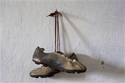 Pair of football shoes hanging on nail