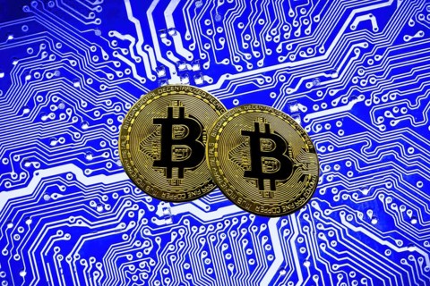 Bitcoin BTC crypto currency gold coins on a mainboard