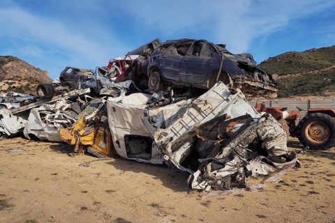 Scrapped and dented cars stacked on top of each other