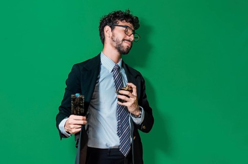 Elegant businessman perfuming himself and combing his hair