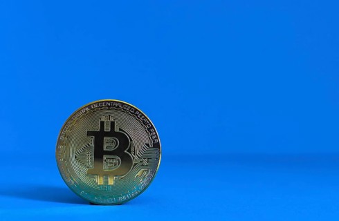 Bitcoin BTC crypto currency gold coin on blue background