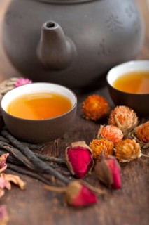 Chinese style herbal floral tea over wood table with raw ingredients