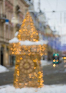 Blurred Christmas lights with famous Clock Tower on Herrengasse street in the city center of Graz