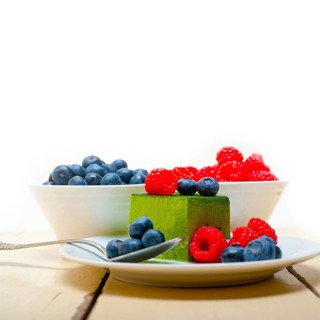 Green tea matcha mousse cake with raspberries and blueberries on top