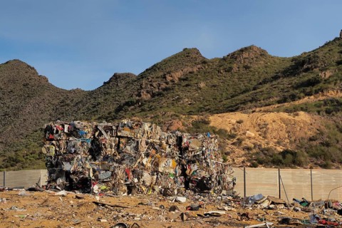 Crushed metal waste in cube on scrap yard
