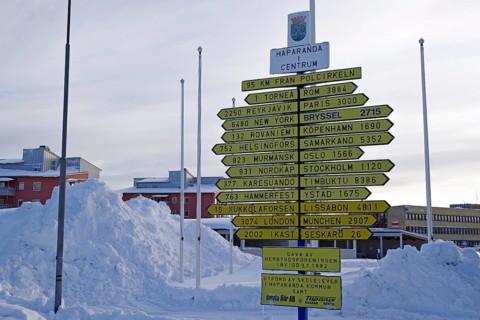 Signposts in front of snow masses in the centre of Haparand