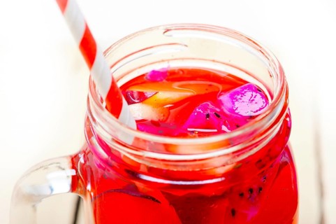 Fresh fruit punch refreshing summer drink over white rustic wood table