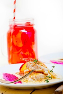 Sea bream orata fillet butter pan fried with fresh peach prune and dragonfruit slices thyme on top