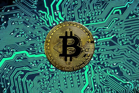 Bitcoin BTC crypto currency gold coins on a mainboard