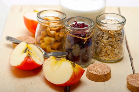 Healthy breakfast ingredients milk oat cashew nuts dried cramberry craisinns