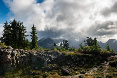 Hiker in front of cloudy Mt. Shuksan with snow and glacier
