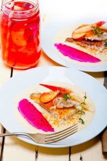 Sea bream orata fillet butter pan fried with fresh peach prune and dragonfruit slices thyme on top