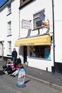 People sitting outside Pieseas chippy chip shop. Harwich
