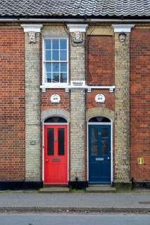 Doors of two Victorian red brick houses next to each other