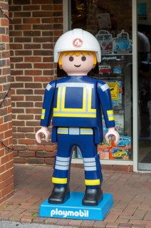Giant Playmobil character model outside toy shop