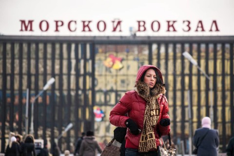 A beautiful young woman walking in front of the harbour in Vladivostok