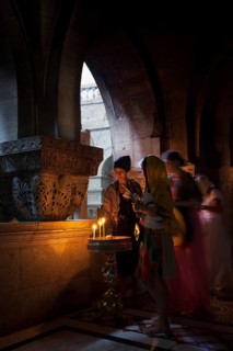 Believers lighting a candle at the Greek Orthodox Chapel inside the Crusader Church within the walls of ancient Jerusalem
