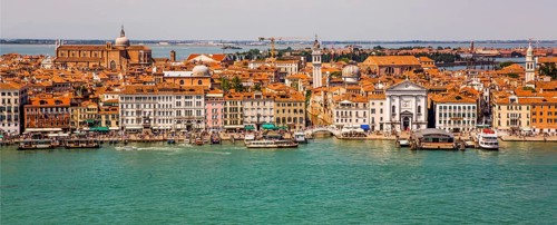 View of the waterfront and Castello district with Pieta church and Chiesa di San Giorgio dei Greci with the leaning tower