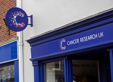 Cancer Research UK charity shop signs outside High Street store