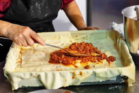 Preparing a lasagne in the kitchen of an agriturismo