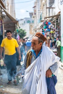 An elderly Berber in traditional clothes with incense