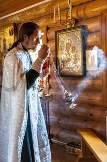 A Russian Orthodox priest in a traditional wooden church during the ceremony