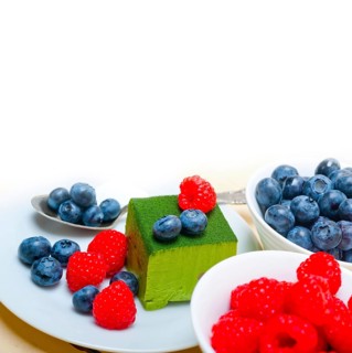 Green tea matcha mousse cake with raspberries and blueberries on top