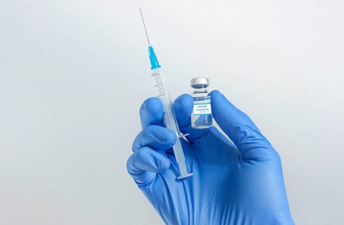 Doctor hands holding a vaccine bottle and syringe