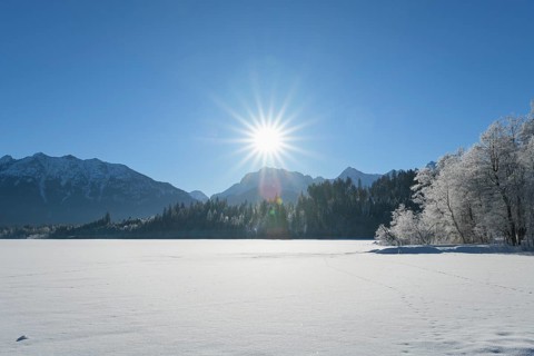 Frozen lake Barmsee with Karwendel mountainrange on morning with sun in winter