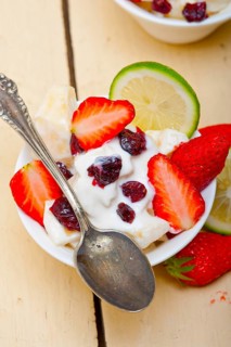 Fruit and yogurt salad healthy breakfast over white wood table