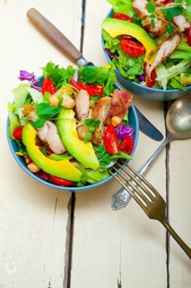 Fresh and healthy Chicken Avocado salad over rustic wood table