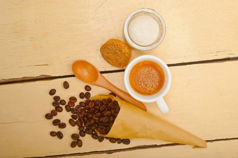 Espresso coffee and beans on a paper cone cornucopia over white background