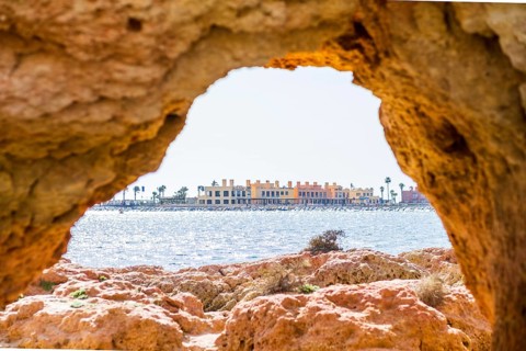 Beautiful sandstone arch with the view from Ferragudo to marina in Portimao