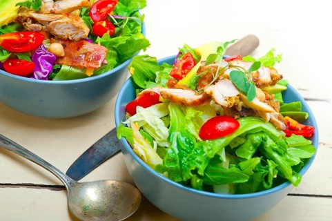 Fresh and healthy Chicken Avocado salad over rustic wood table