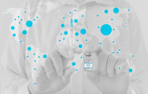 World map and doctor hands holding a vaccine bottle and syringe